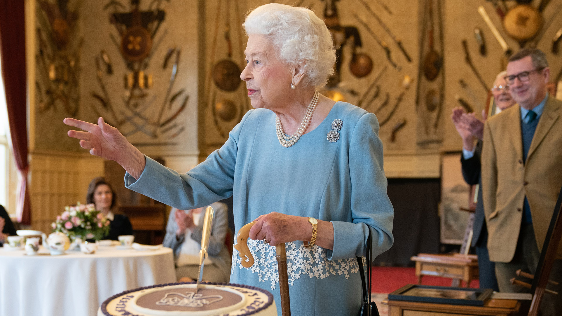 La reina Isabel con el bastón de su marido corta la tarta en Sandringham
