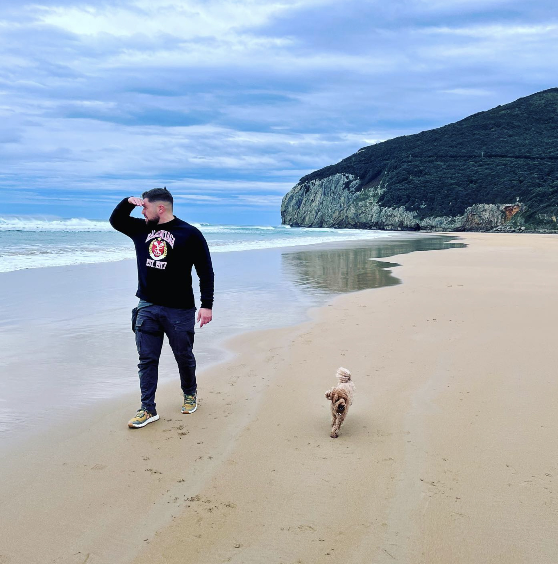 Kike en la playa junto a su mascota.
